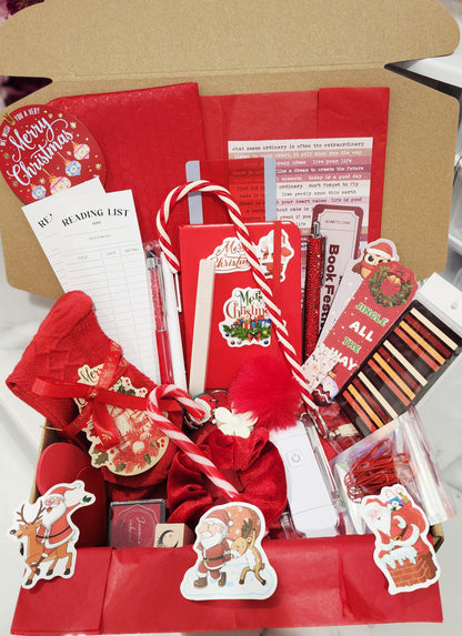 Christmas-themed gift box with stationery items and festive decorations.