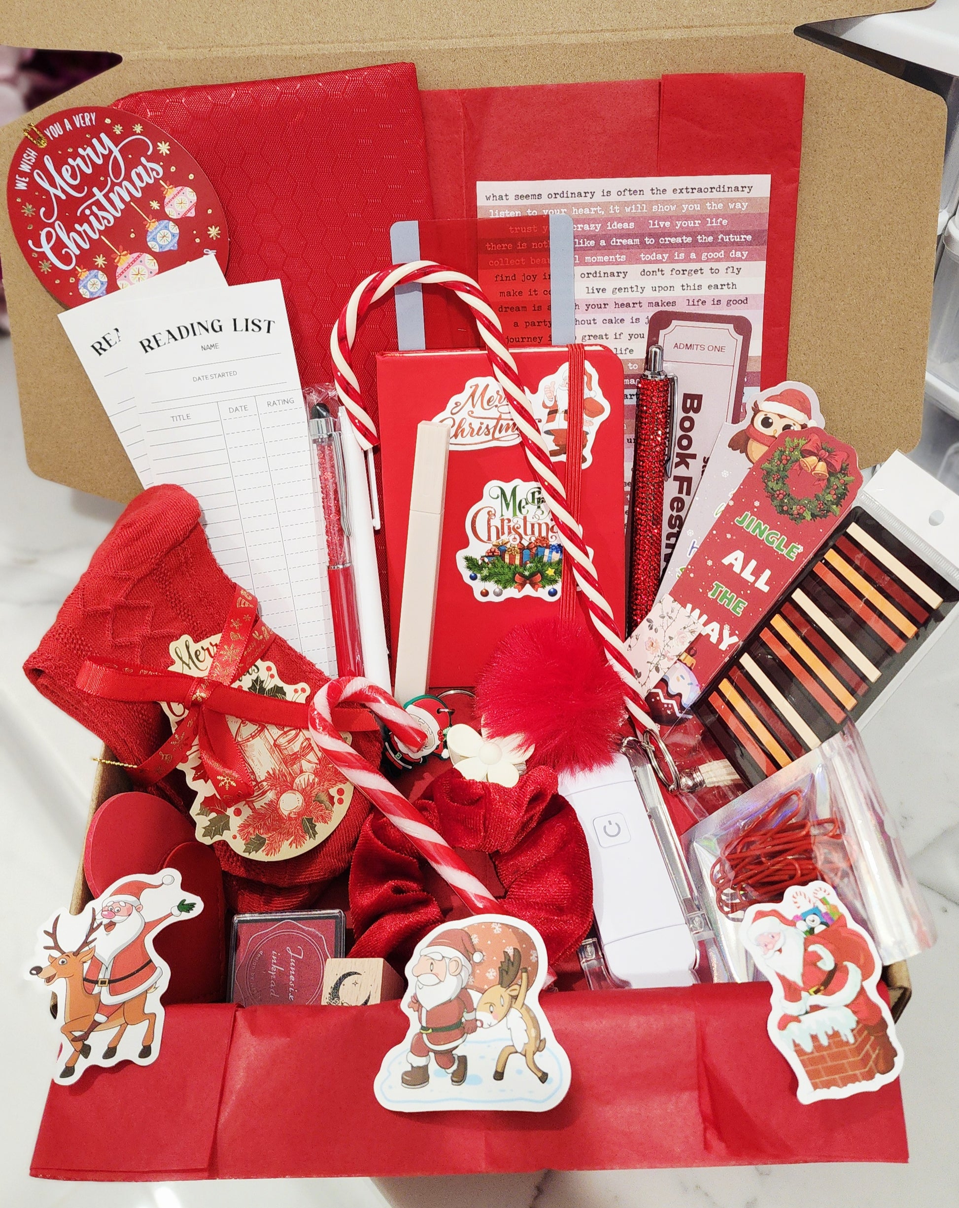 Collection of Christmas-themed stationery items including cards, flags, and a pen on a white surface.